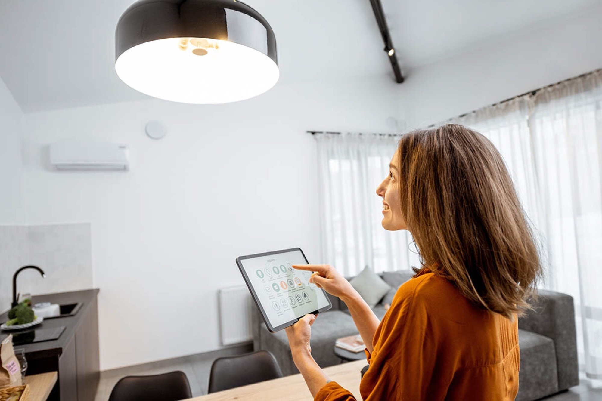 Homeowner adjusting Lutron lighting scenes from a tablet