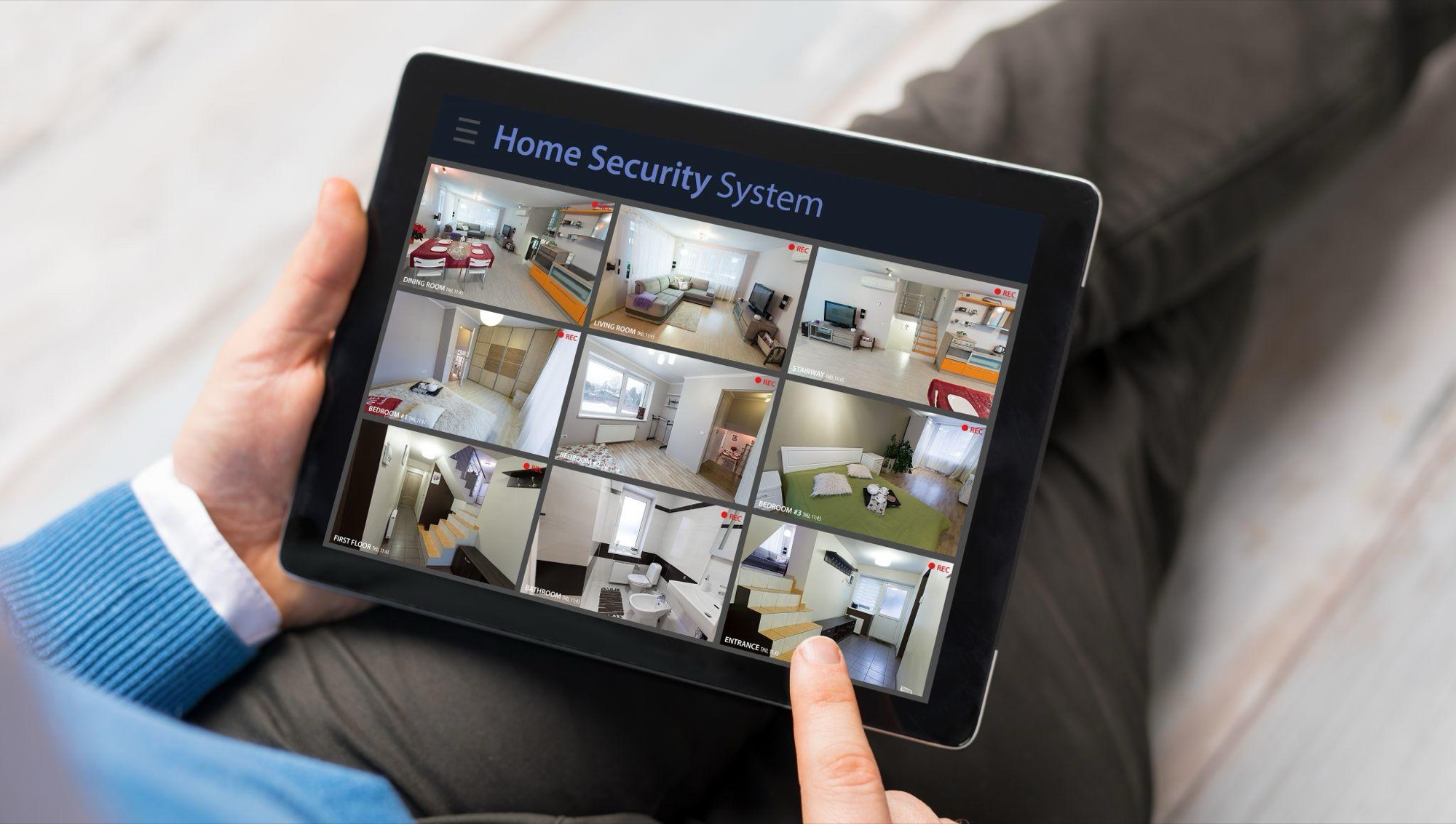 Homeowner viewing live camera feeds from every room on a tablet